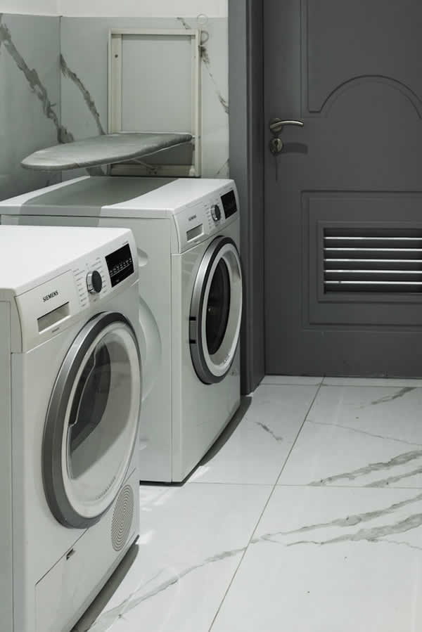 washer, dryer, ironing board in laundry room