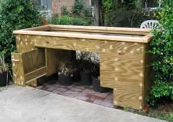 This raised garden bed has a raised bottom which provides good knee space and drawers for garden tools.