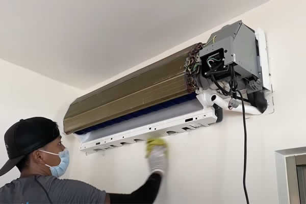 man repairing indoor air conditioning unit