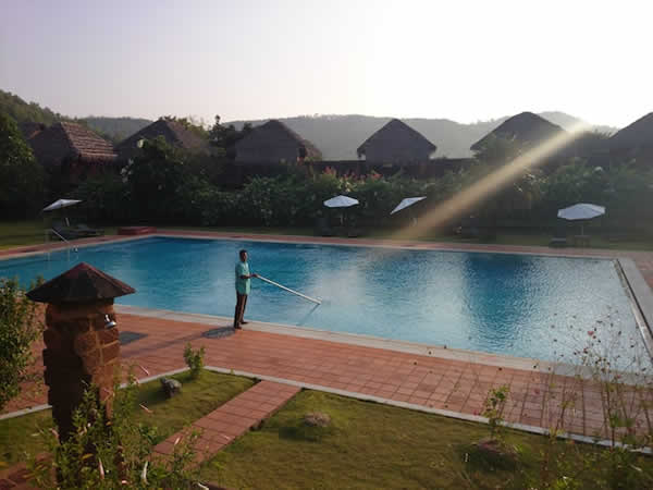 man cleaning a swimming pool