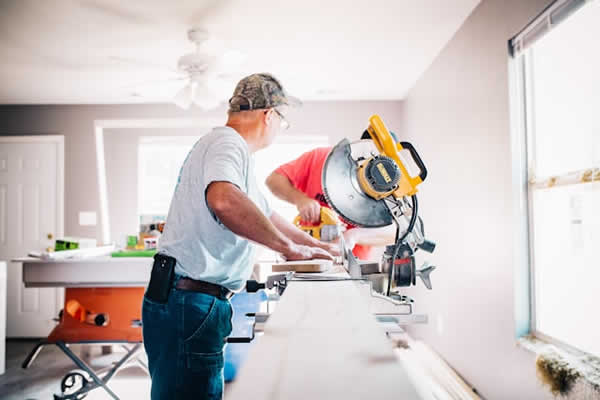 man cutting lumber with a chop saw