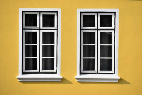 two casement windows on yellow wall