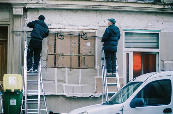 2 workmen working on the exterior of a building