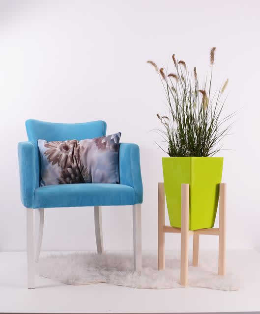 large flower pot with plant next to chair
