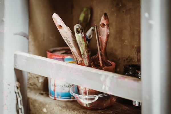 paint brushes in a jar on a shelf