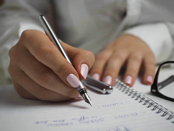 woman writing a note on paper