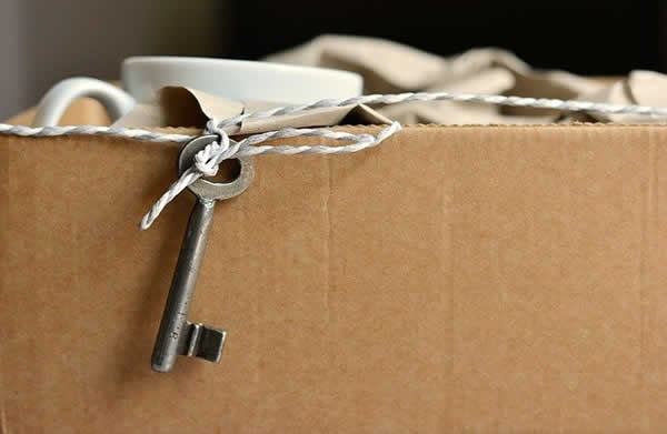 key attached with twine to moving box