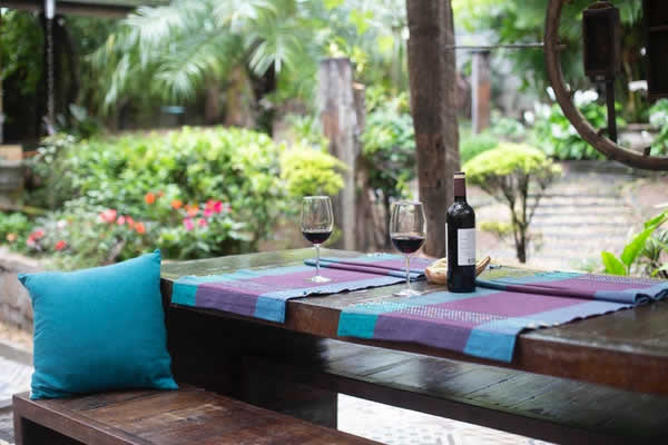 table outdoors with 2 wine glasses and bottle of wine