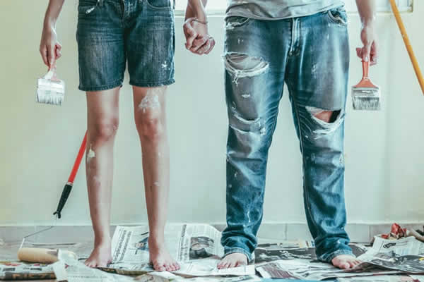 a woman and man shown from waiste down covered in paint as they have been painting